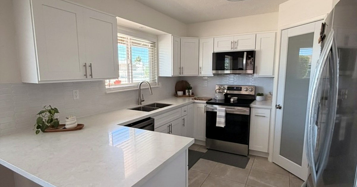 Completed Hesperia kitchen remodel with white cabinets, quartz peninsula and stainless steel appliances