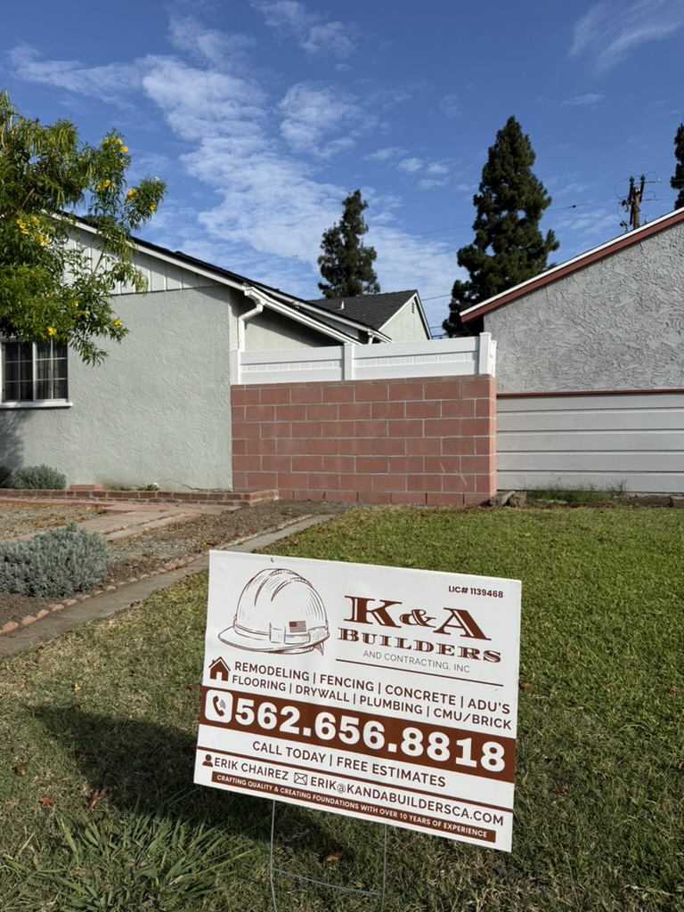 Completed Lanett block wall in Whittier with red concrete masonry, white vinyl privacy topper and K&A Builders project sign